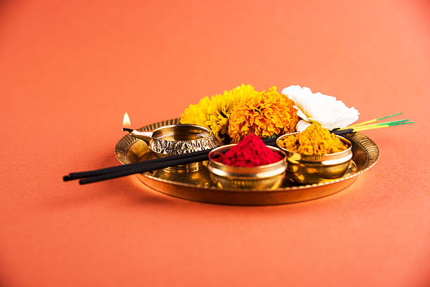 hindu puja thali, indian culture Beautifully Decorated Pooja Thali for diwali celebration to worship, huldi or turmeric powder and kumkum, flowers, scented sticks in brass plate on orange background, hindu puja thali durga stock pictures, royalty-free photos & images