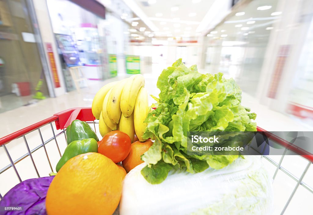 Supermarket interior, filled with the fruit and  Vegetables Supermarket interior, filled with the fruit and  Vegetables of the shopping cart. Aisle Stock Photo