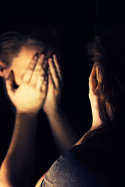istock Woman covering her face in the dark 511789778