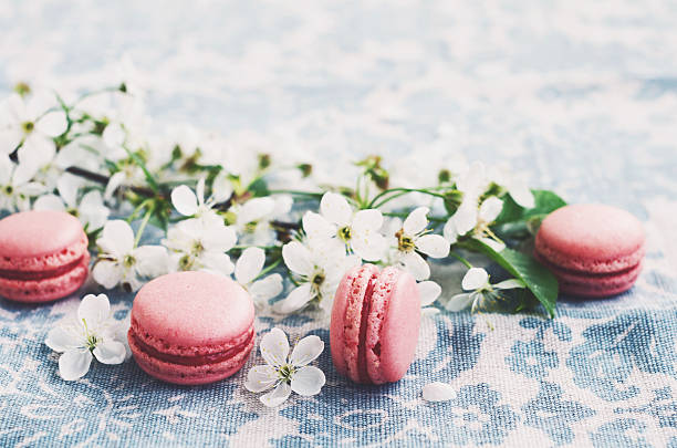 istock Pink macaroons and white flowers at vintage tablecloth 511790134