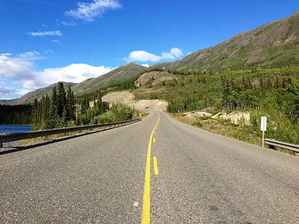 A shot of the Klondike Highway between Carcross and Whitehorse in Canada's Yukon Territory. This section is along Emerald Lake. Theme of open/empty road, exploration, road trip, driving.