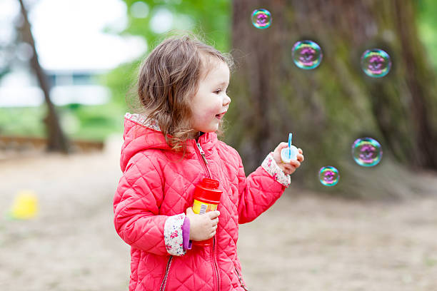 istock Cute little girl having fun with soap bubbles 511790544
