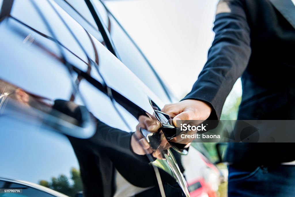 Chauffeur open car door Female chauffeur opening a luxury car door. Car Stock Photo