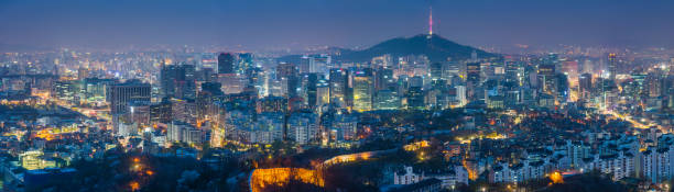 Seoul South Korea futuristic cityscape skyscrapers landmarks illuminated at night Sweeping panoramic vista over the landmarks and lights of Seoul, Korea's crowded and colourful capital city, from the historic palaces of Gyeongbokgung and the ancient fortress walls across the futuristic neon lights of downtown, past the iconic spire of Seoul Tower on Namsan mountain to the modern high rises of Gangnam and beyond. ProPhoto RGB profile for maximum color fidelity and gamut. kangnamgu stock pictures, royalty-free photos & images