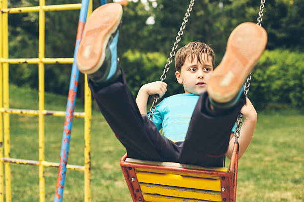 istock Cute Blond Boy Swinging at the Playground 511793700