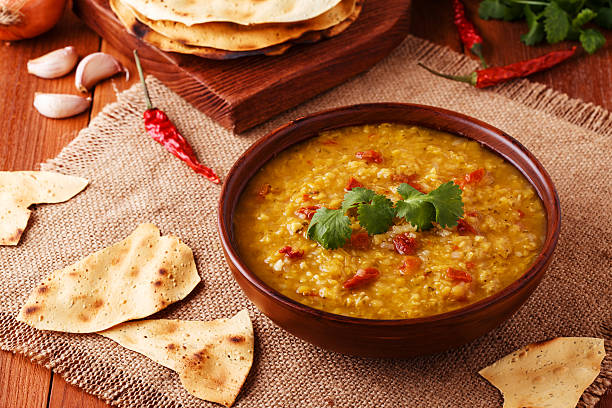 istock Thick indian red lentil soup served with indian flat bread. 511793876