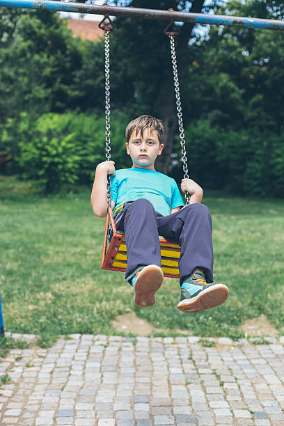 istock Cute Blond Boy Swinging at the Playground 511793882
