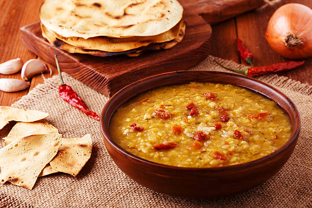 istock Thick indian red lentil soup served with indian flat bread. 511794054