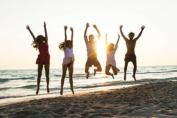 istock Five happy friends jumping on the beach for summer 511794734