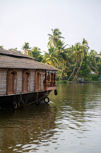 Kerala, India - October 16, 2015: Unindetified man at backwaters in Kerala, India. The backwaters are an extensive network of 41 west flowing interlocking rivers, lakes and canals that center around Alleppey, Kumarakom and Punnamada