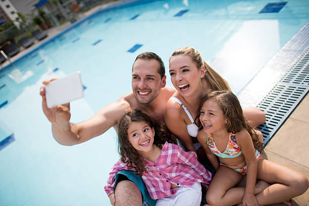 Happy family taking a selfie by the pool