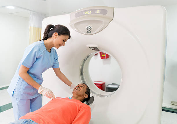 Patient getting a CAT scan at the hospital Patient getting a CAT scan at the hospital and talking to the nurse - medical exam concepts cat scan stock pictures, royalty-free photos & images