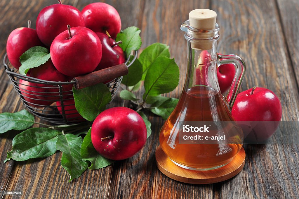apples and apple cider vinegar apples in a basket and apple cider vinegar in a bottle Autumn Stock Photo