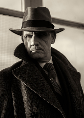 Black and white portrait image of a mature man dressed as a 1940s gangster character.