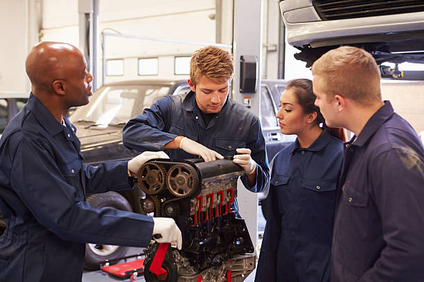 istock Teacher Helping Students Training To Be Car Mechanics 511803103