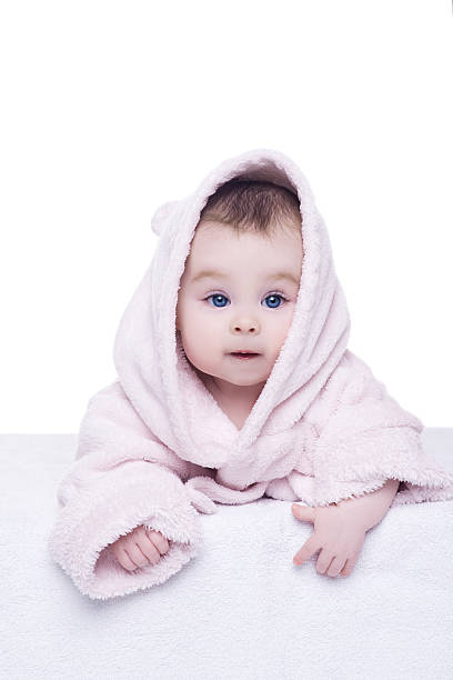 istock baby girl in pink bathrobe lying on her belly 511804568