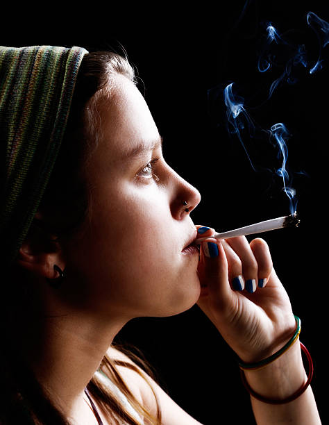 istock Pretty young rebel smokes a joint dreamily 511805151