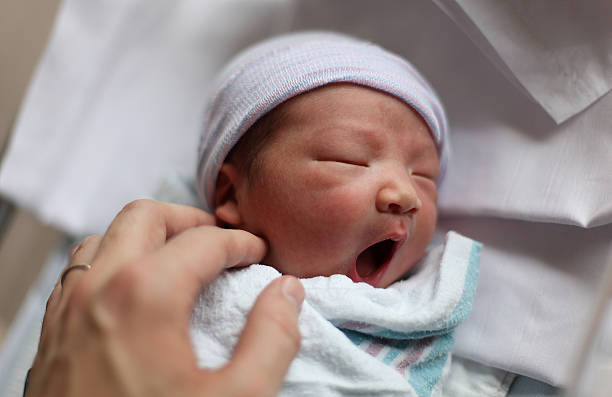 nouveau-né bébé réagit en douceur. - baby yawning asian ethnicity newborn photos et images de collection