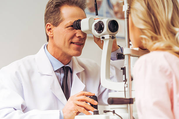 At the ophthalmologist Handsome ophthalmologist examining beautiful woman's eyes with modern equipment ophthalmologist stock pictures, royalty-free photos & images