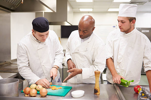 professor ajudar os alunos a trabalhar na formação de catering - chef trainee cooking teenager imagens e fotografias de stock