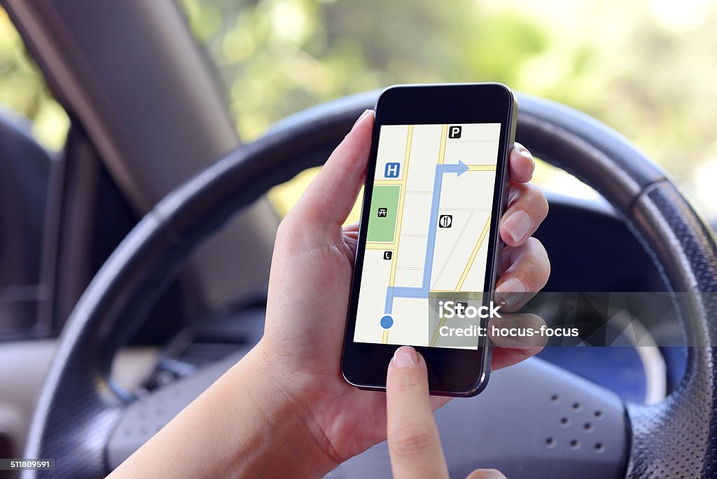 Navigation with smart phone Woman holding smart phone displaying map in a car. Adult Stock Photo