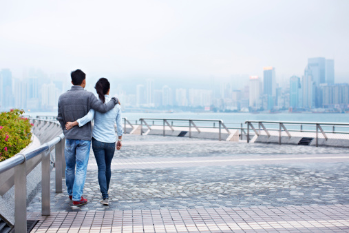 Rearview shot of a young couple walking along the Hong Kong waterfront
