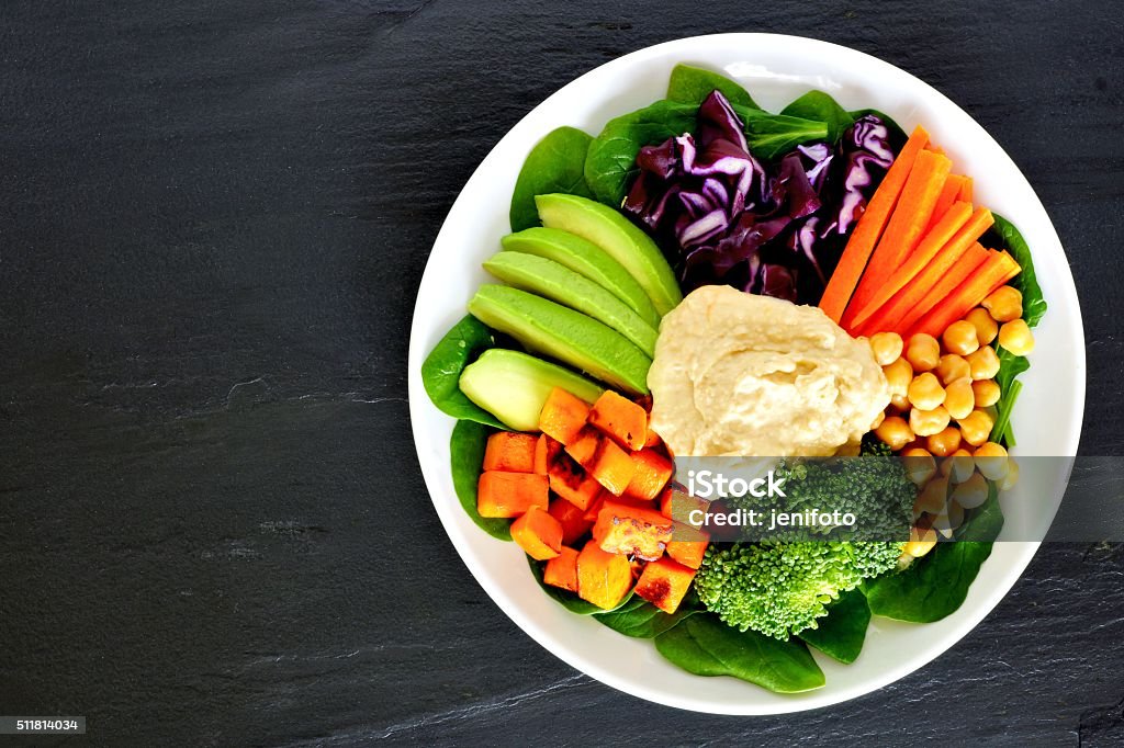 Healthy lunch bowl with super-foods and mixed vegetables Healthy nourishment bowl with super-foods and fresh mixed vegetables, overhead view on dark slate Hummus - Food Stock Photo