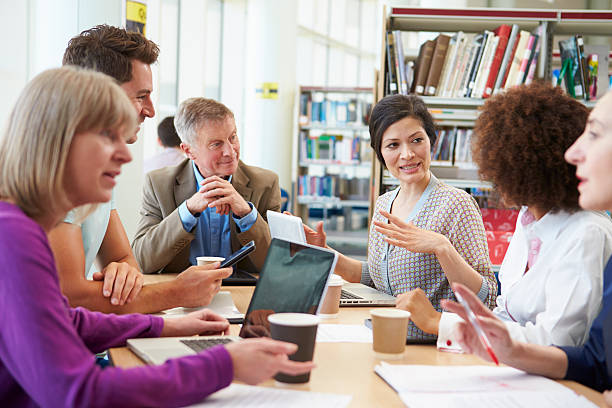 istock Group Of Mature Students Collaborating On Project In Library 511846359