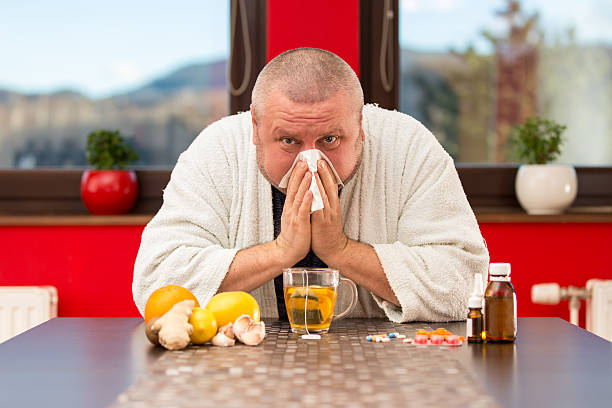 istock Sick man suffering cold and winter flu virus drinking tea 511849172