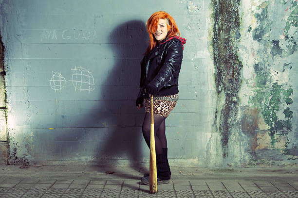 istock Smiling punk woman posing with a baseball bat. 511849458