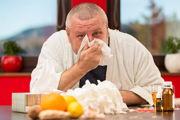 istock Sick man suffering cold and winter flu virus drinking tea 511849620