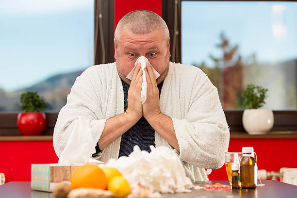 istock Sick man suffering cold and winter flu virus drinking tea 511849660
