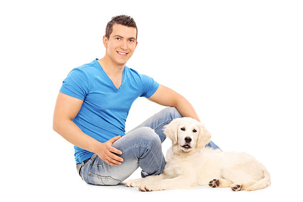 istock Man chilling out with his puppy seated on floor 511850407