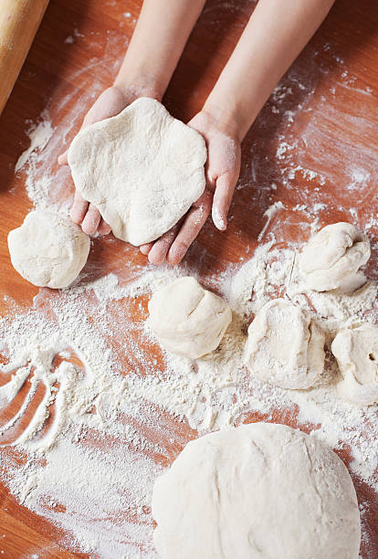 istock Child cooking. Kneading dough on table 511850901