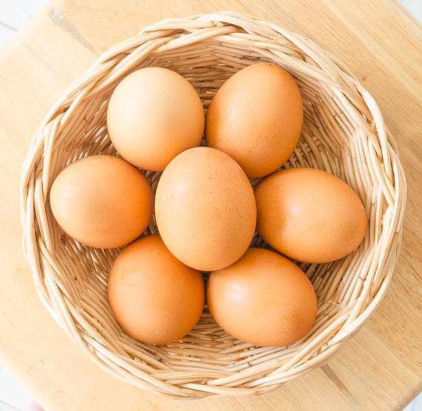istock Eggs in a wicker basket on wooden table 511853136