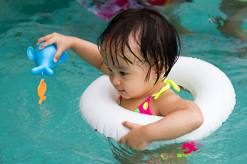 Asian Little Chinese Girl Playing in Swimming Pool with Swimming Circle
