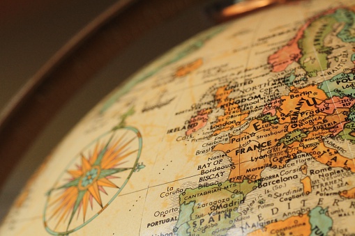 Close up of an antique globe focusing on the countries that make up Western Europe and their surrounding bodies of water.