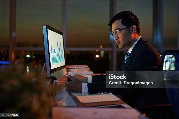 Examining Business Chart Stock Photo - Download Image Now - Night, Businessman, Computer Monitor