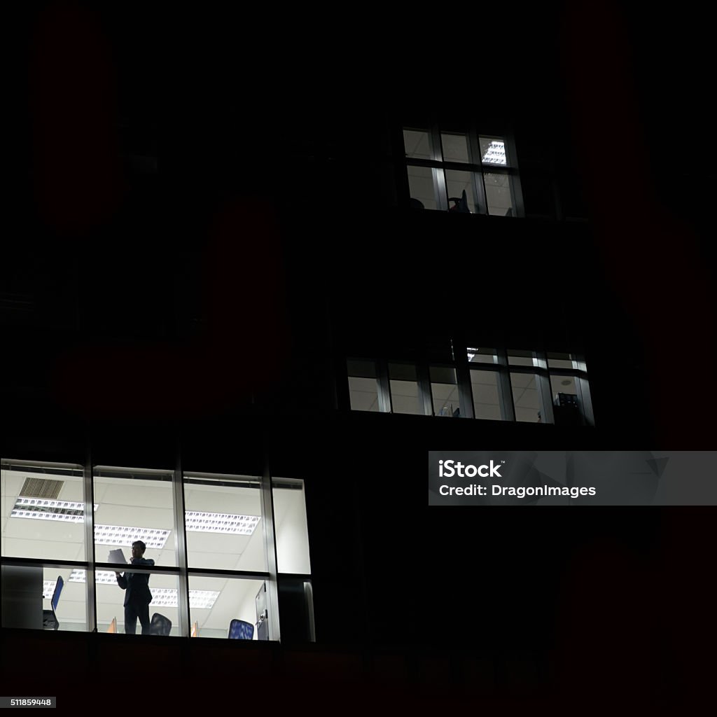 Dark office building Dark office building with business person working inside Night Stock Photo