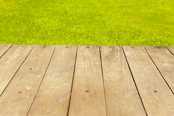 istock Wood planks floor with green grass on the background. 511862416