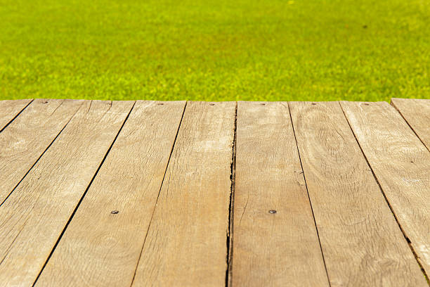 istock Wood planks floor with green grass on the background. 511862432