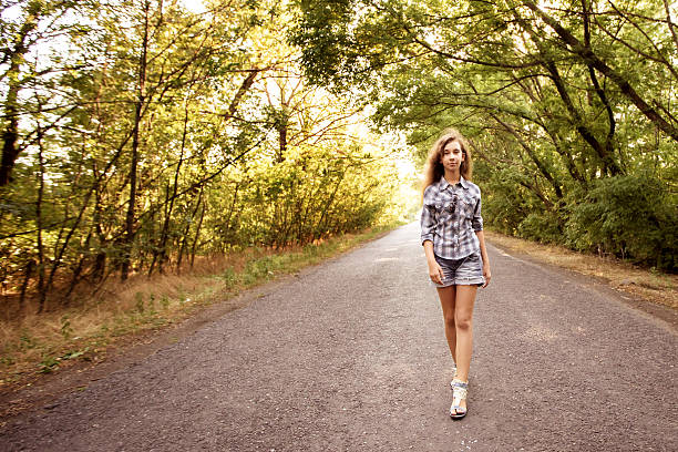 istock beautiful girl walking on empty road 511862698