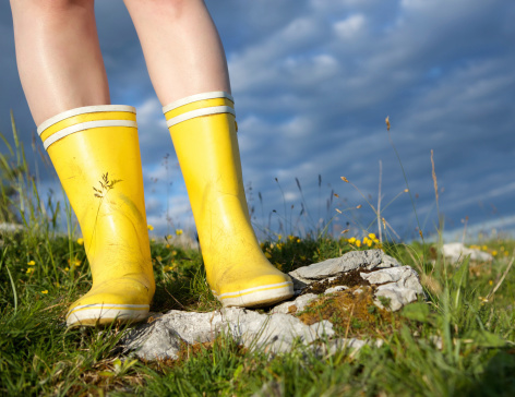 Low angle view of a female standing in yellow boots outdoors