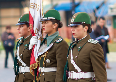 Santiago, Сhile - August 12, 2014: Members of the Carabineros marching with a ceremonial flag as part of the changing of the guard ceremony at La Moneda in Santiago, Chile. La Moneda is the Presidential Palace in the centre of Santiago.
