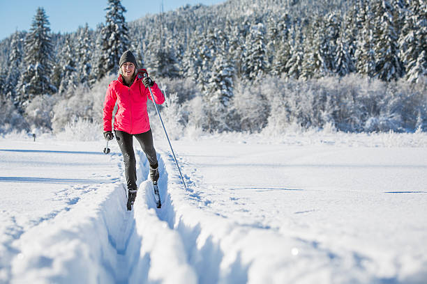 Woman cross country skiing on sunny day. stock photo