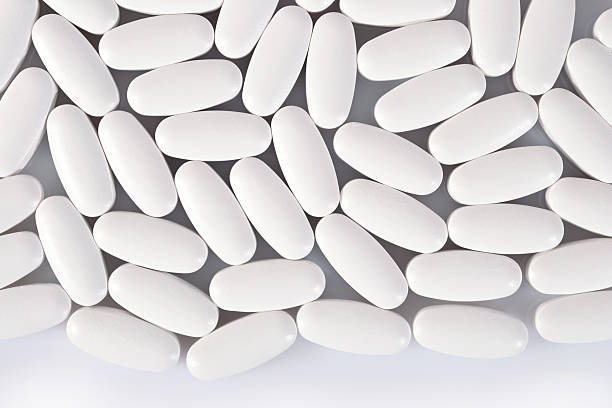 istock Top view of white pills on a white 511868048
