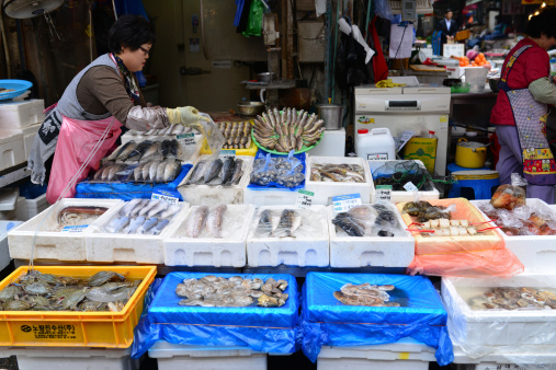 Seoul, South Korea - April 16, 2014: Hawker sells fish in the Namdaemun market. Namdaemun Market, located in the center of Seoul, is the biggest traditional market in Korea.