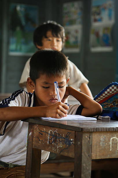 Three Elementary School Boys With Indonesian Flags And Laptop Smiling At The Camera