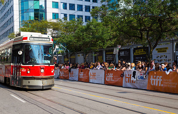 Spectators on the street for Tiff Toronto, Canada - September 9, 2014: Spectators on on the street for the Tiff festival in Toronto. A streetcar can be seen moving along the road toronto international film festival stock pictures, royalty-free photos & images