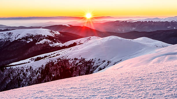Sunset in snowy mountains stock photo
